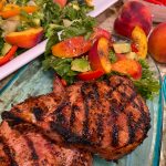 Grilled peach pork chops served with fresh peach salad and avocado, a summer grilling recipe from Food Style Uncorked.